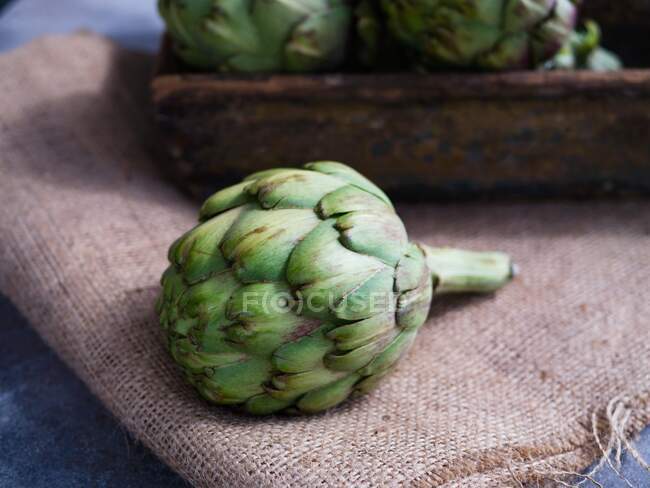 Fresh artichoke on sackcloth — Stock Photo