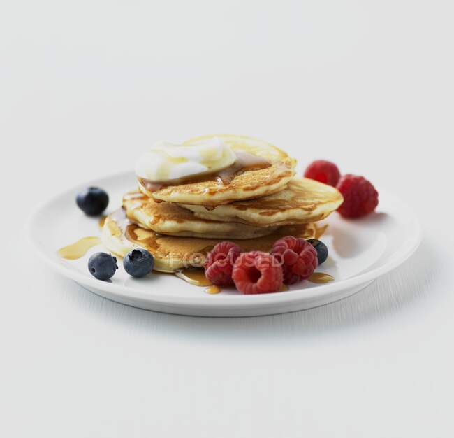 Pancakes with berries, yoghurt and maple syrup — Stock Photo