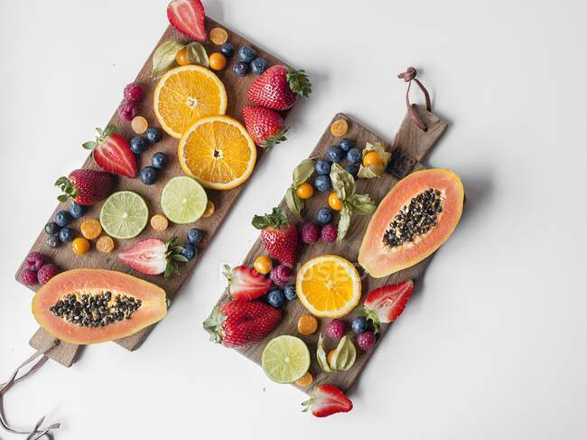 Frutas frescas dispuestas en dos tablas de madera - foto de stock