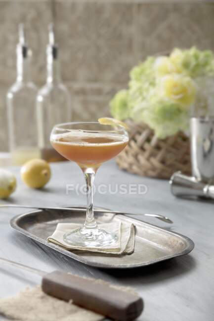 Cóctel con bourbon y jarabe de miel en la mesa de estilo con flores - foto de stock