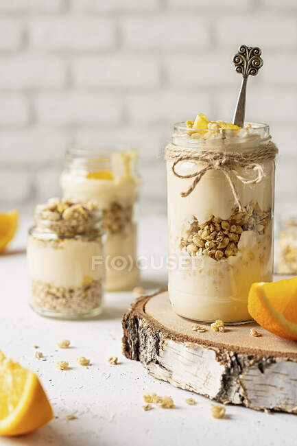 Yogur de naranja con granola servido en frascos - foto de stock