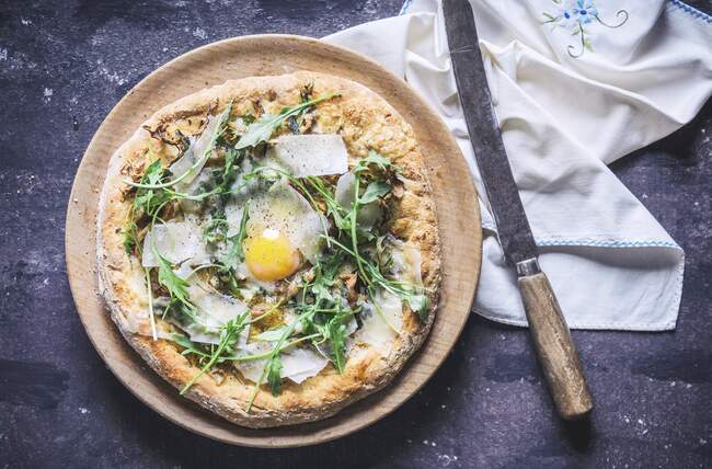 A pizza with rocket, fried egg and parmesan (seen from above) — Stock Photo