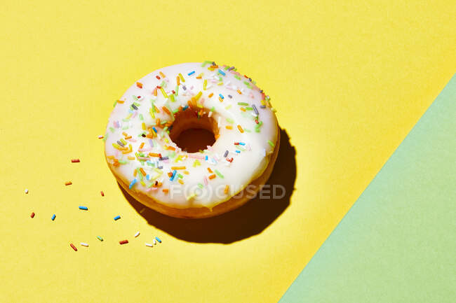 Donut espolvoreado sobre fondo colorido - foto de stock
