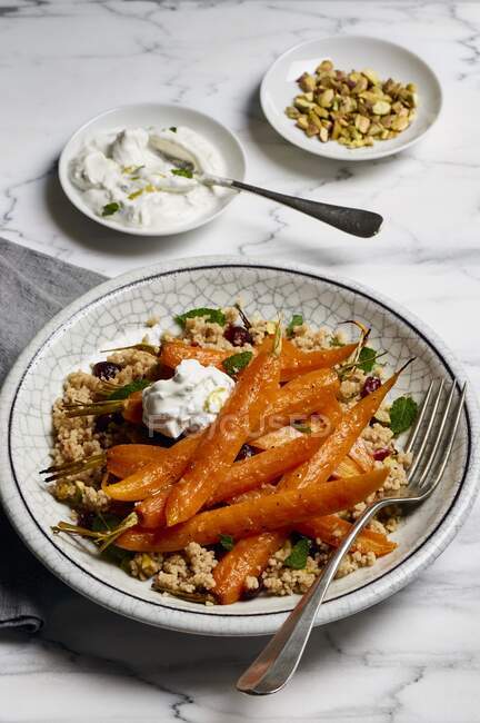 Oven roasted carrots with couscous, mint, pistachios, cranberries and a lime and yogurt dip — Stock Photo