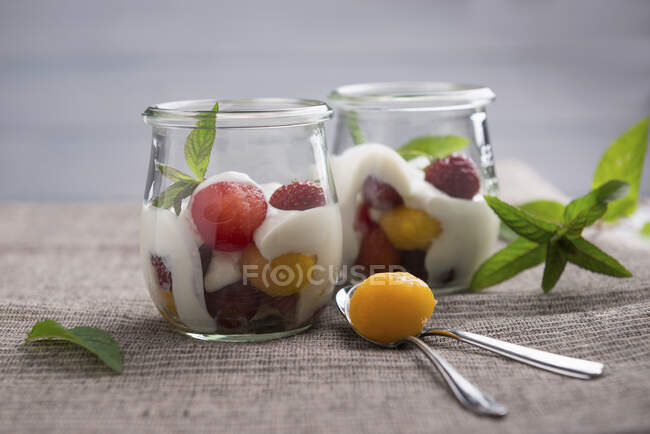 Соєвий йогурт з динею та персиковою кулькою, полуницею та червоним виноградом — стокове фото