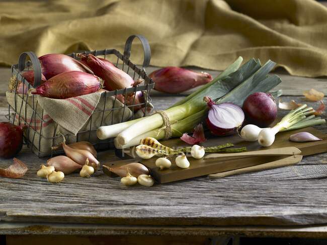 An arrangement of onions and leeks — Stock Photo