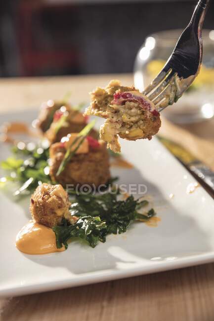 Crawfish corn fritters on fork and plate — Stock Photo