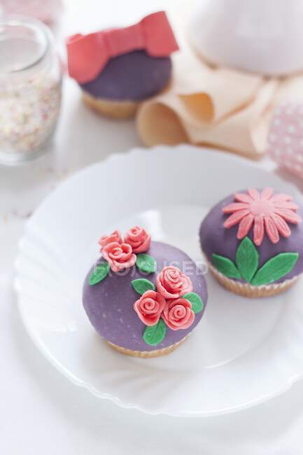 Cupcakes with colorful floral sugar decorations — Stock Photo