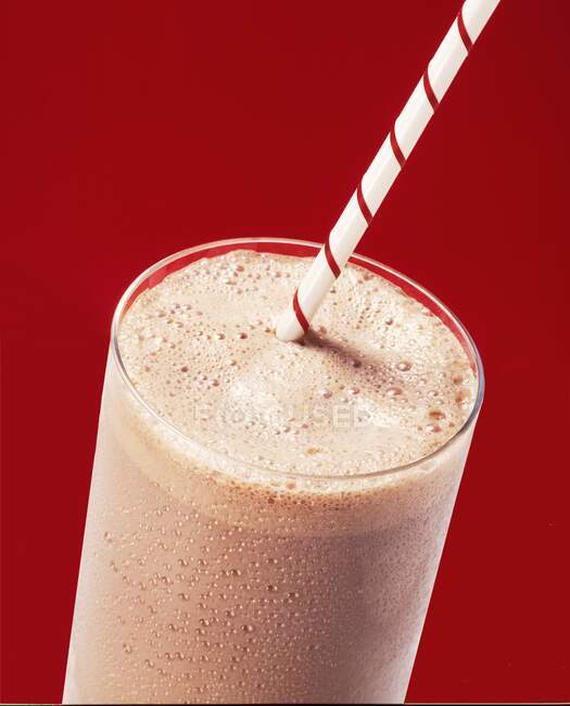 Milkshake al cioccolato in un bicchiere con una cannuccia — Foto stock