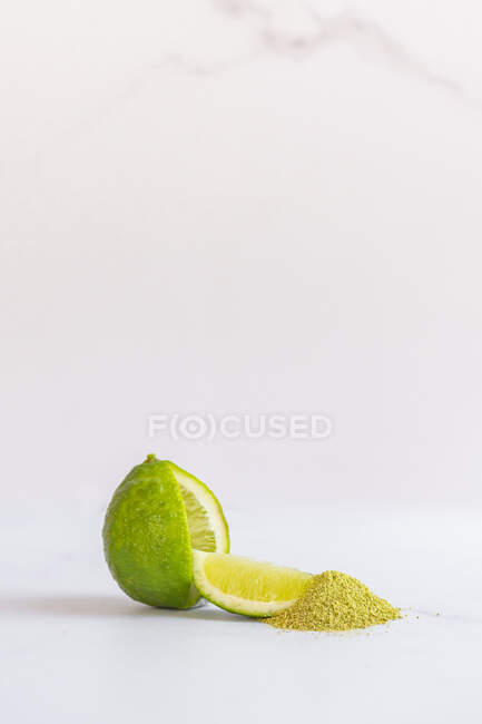 Lime with wedge and lime fruit powder — Stock Photo
