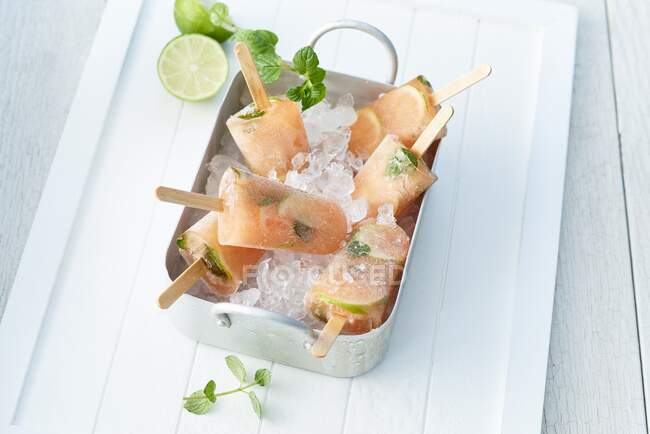 Limetten-Papaya-Eis mit Minze auf Crushed Ice in einer Metallschüssel — Stockfoto