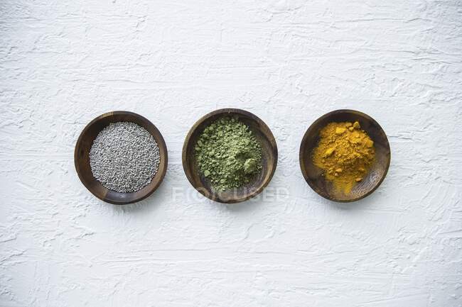 Superfood in small bowls (chia seeds, matcha powder and turmeric powder) — Stock Photo