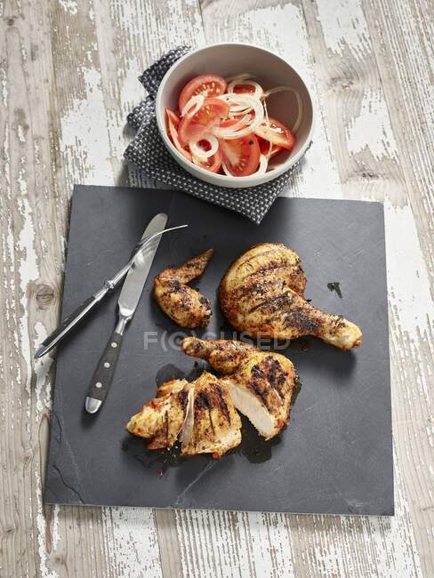 Piri piri chicken with tomato and onion salad — Stock Photo