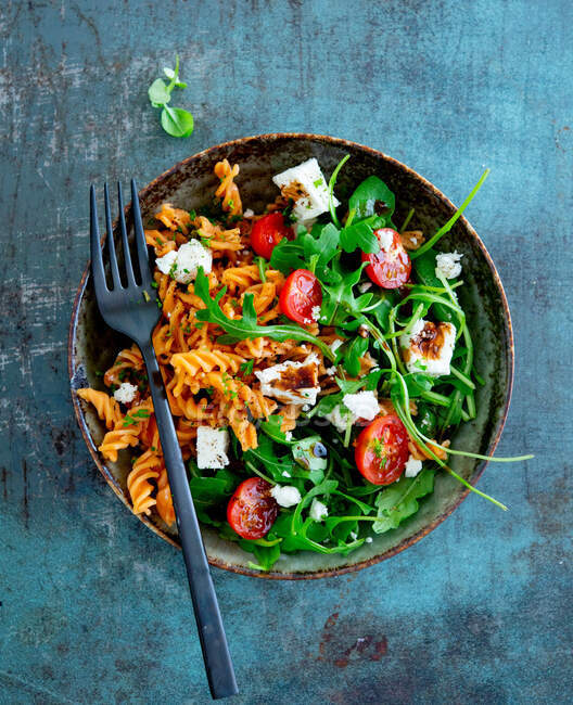 Bowl with fusilli, tomatoes, rocket and feta cheese — Stock Photo