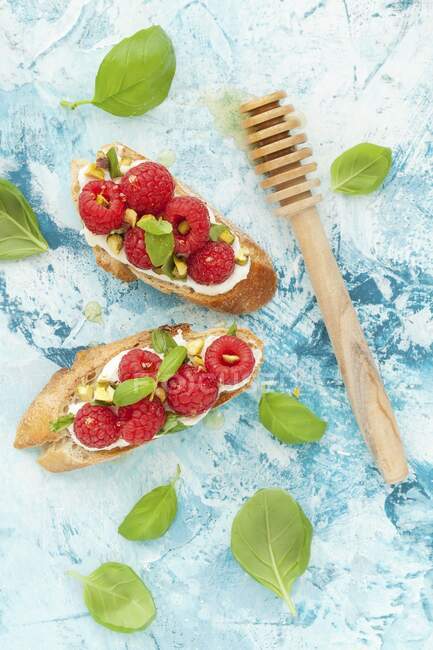 Crostini with ricotta, raspberries, pistachios and basil — Stock Photo