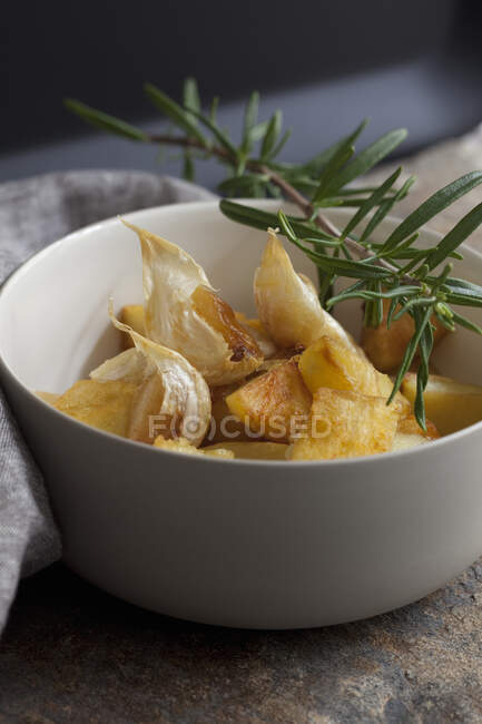 Garlic potatoes with rosemary served in bowl — Stock Photo