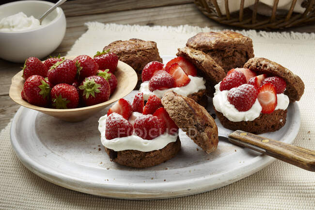 Chocolate spelt scones with whipped cream and fresh strawberries — Stock Photo