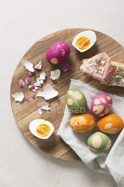 Ovos de Páscoa e sanduíches de presunto abertas em umas chapas de madeira — Fotografia de Stock