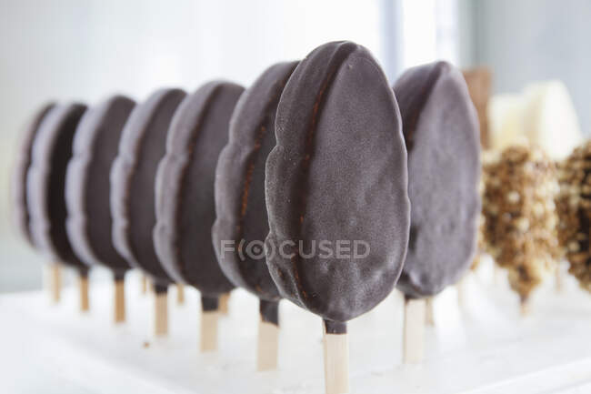 Rows of ice cream lollies with chocolate icing — Stock Photo
