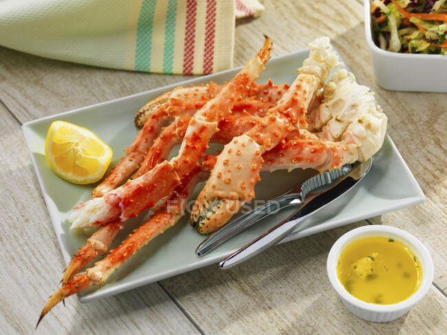 Crab legs with butter and lemons — Stock Photo