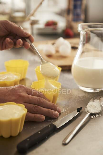 Molds being carefully filled with pudding — Stock Photo