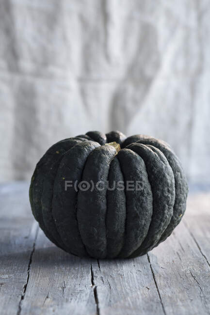 A dark green pumpkin on a wooden table — Stock Photo