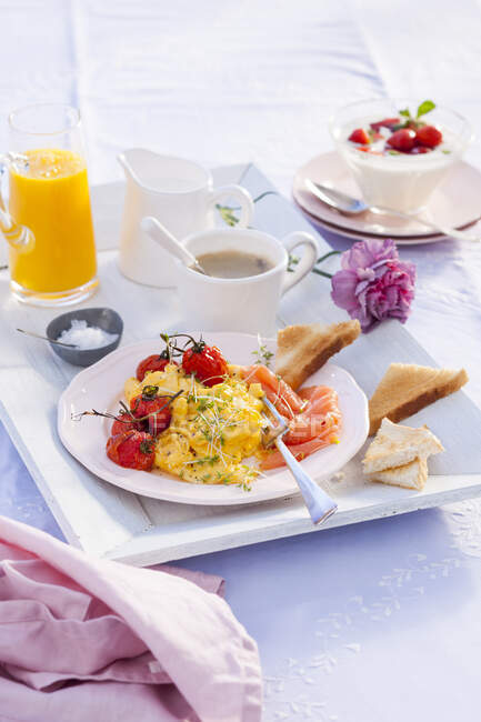 Huevo revuelto con berro, salmón ahumado y tomates cherry para el desayuno - foto de stock