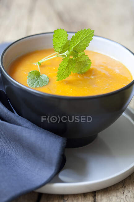 Суп из сквоша с орехами в голубой миске — стоковое фото
