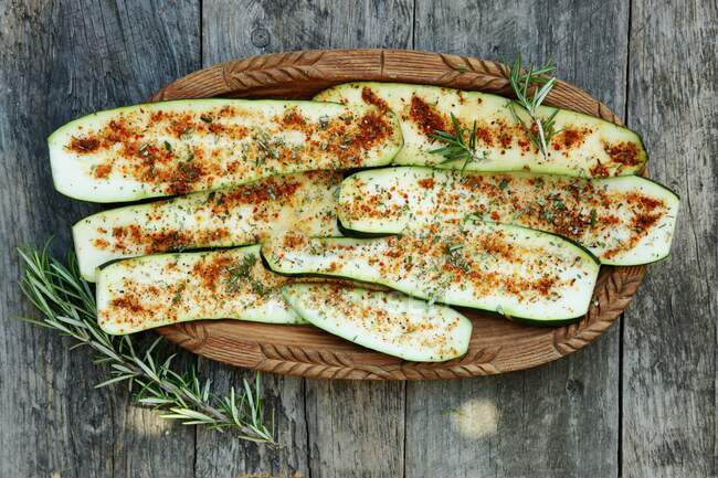 Courgette slices with paprika in a wooden bowl — Stock Photo