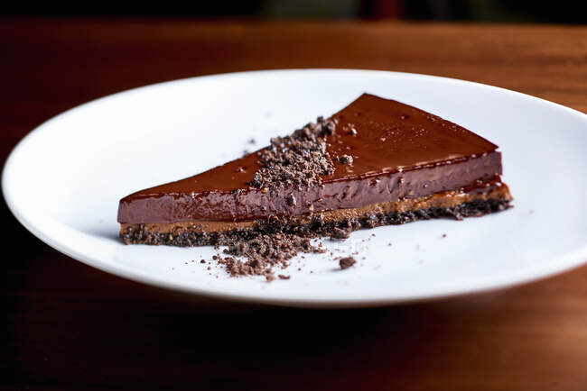 Uma fatia de torta de chocolate em um prato branco — Fotografia de Stock