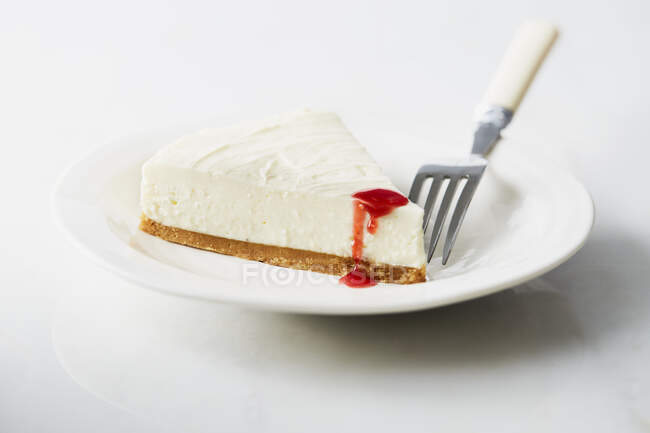 A slice of cheesecake with fruit sauce — Stock Photo