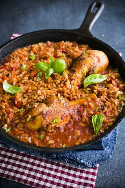 Tomato rice with chicken and basil in pan — Stock Photo
