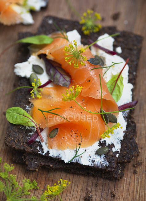 Smoked salmon and cream cheese and herbs on bread — Stock Photo