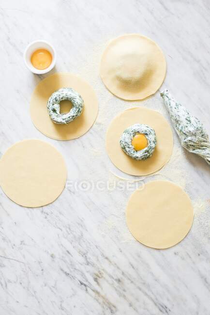 Preparazione di spinaci per la colazione e ravioli di ricotta con tuorlo d'uovo, con pasta fresca — Foto stock