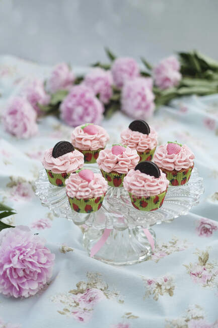 Strawberry cupcakes with pink cream and cookies — Stock Photo