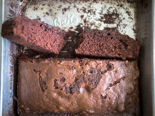 Gâteau au chocolat dans une boîte de cuisson comme image symbole pour la cuisson — Photo de stock