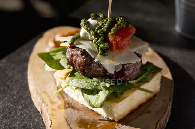 Un hamburger di focaccia con pecorino, ricotta, pesto, spinaci e pomodoro — Foto stock