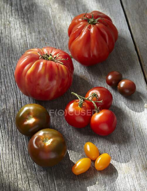 Tomates vermelhos frescos em tábua de madeira — Fotografia de Stock