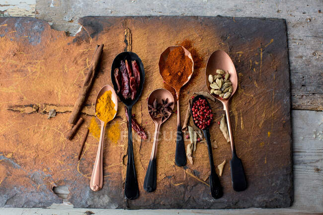 Various herbs in spoons and spices on wooden background. top view with space for text. — Stock Photo