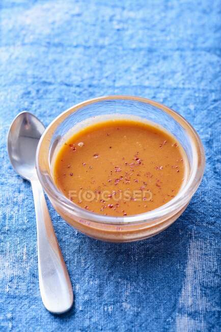 Sauce au poivre dans des bols en verre sur fond bleu — Photo de stock