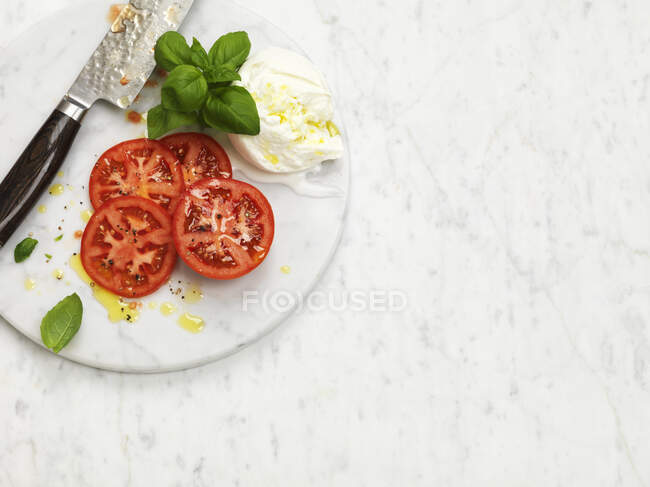 Свіжий салат з помідорами, моцарелою, базиліком та сиром . — стокове фото