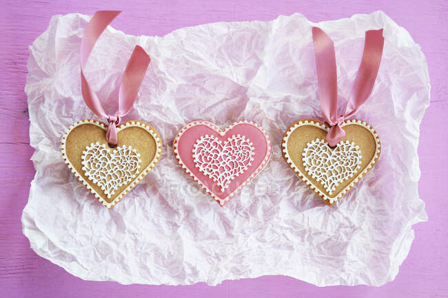 Tre biscotti a forma di cuore su un pezzo di carta — Foto stock