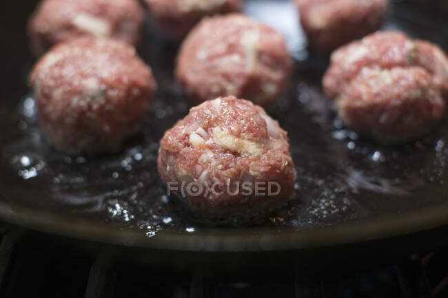 Raw meatballs being fried in a pan — Stock Photo