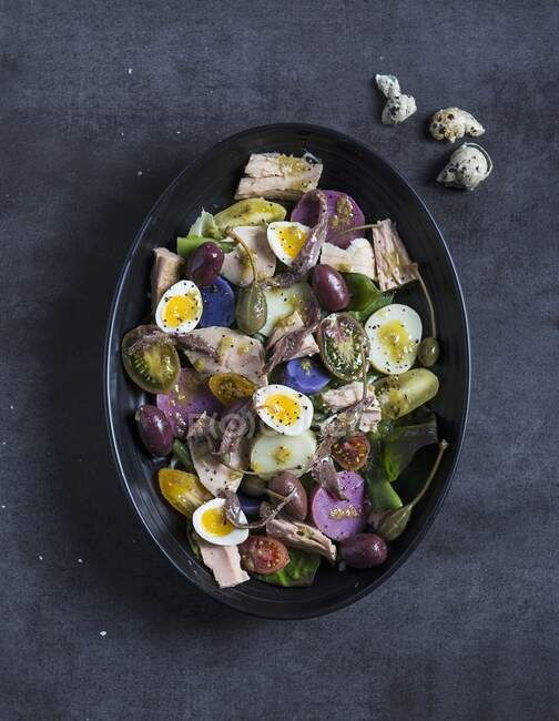 Салат нікейський з тунцем, анчоусами та перепелиними яйцями — стокове фото