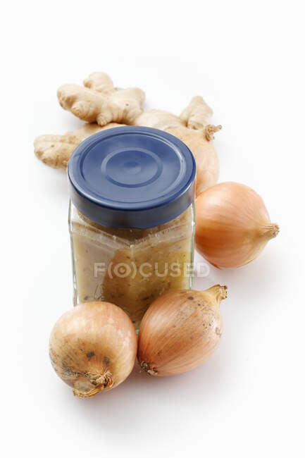 Confiture de gingembre et d'oignons dans un bocal à plateau rond sur une surface blanche — Photo de stock