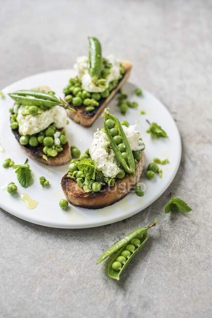Bruschetta with green peas and mozzarella — Stock Photo