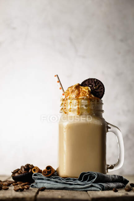 A caramel latte with cream and a cookie — Stock Photo
