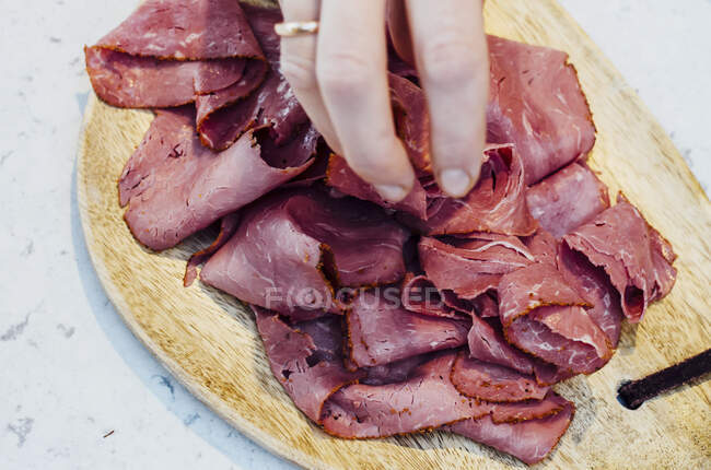 Sliced pastrami on a wooden board — Stock Photo