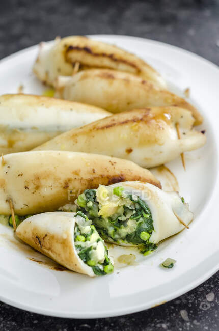 Squid, filled with spinach, potatoes, peas and onions — Stock Photo