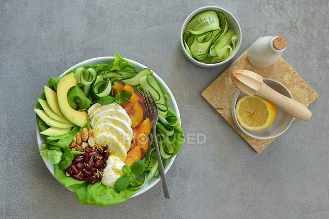 Салат с моцареллой, авокадо, огурцом, красной фасолью, миндалем и мятой — стоковое фото